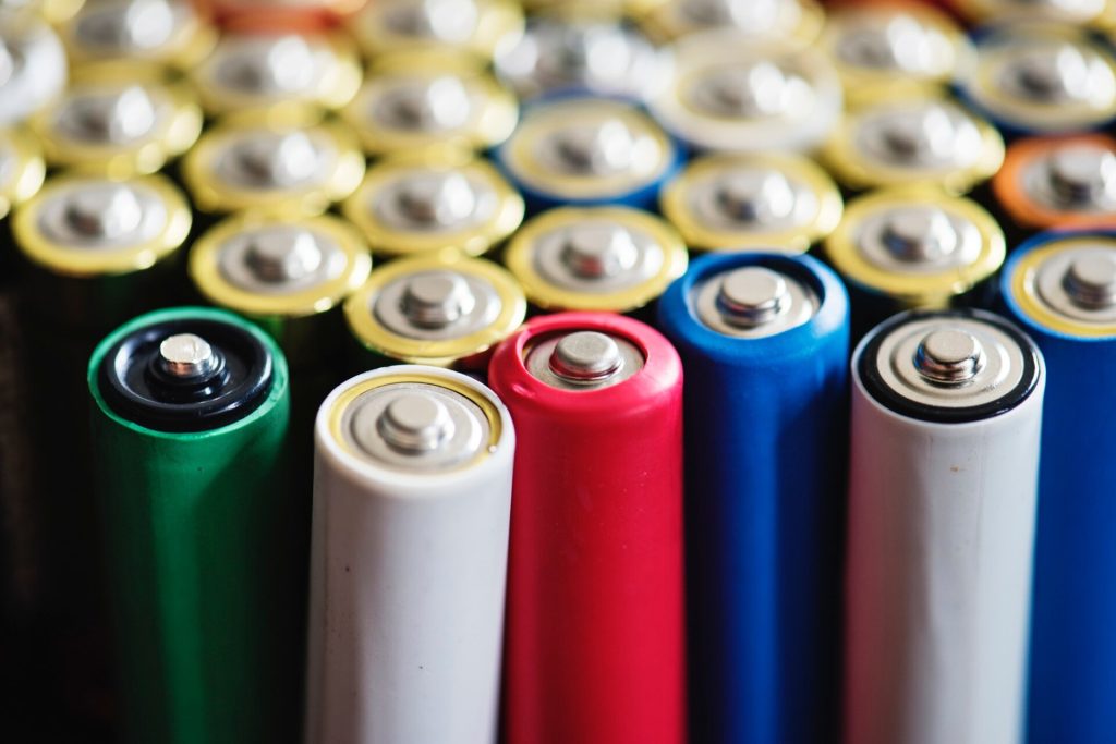 Alkaliska batterier i olika färger stående tätt intill varandra