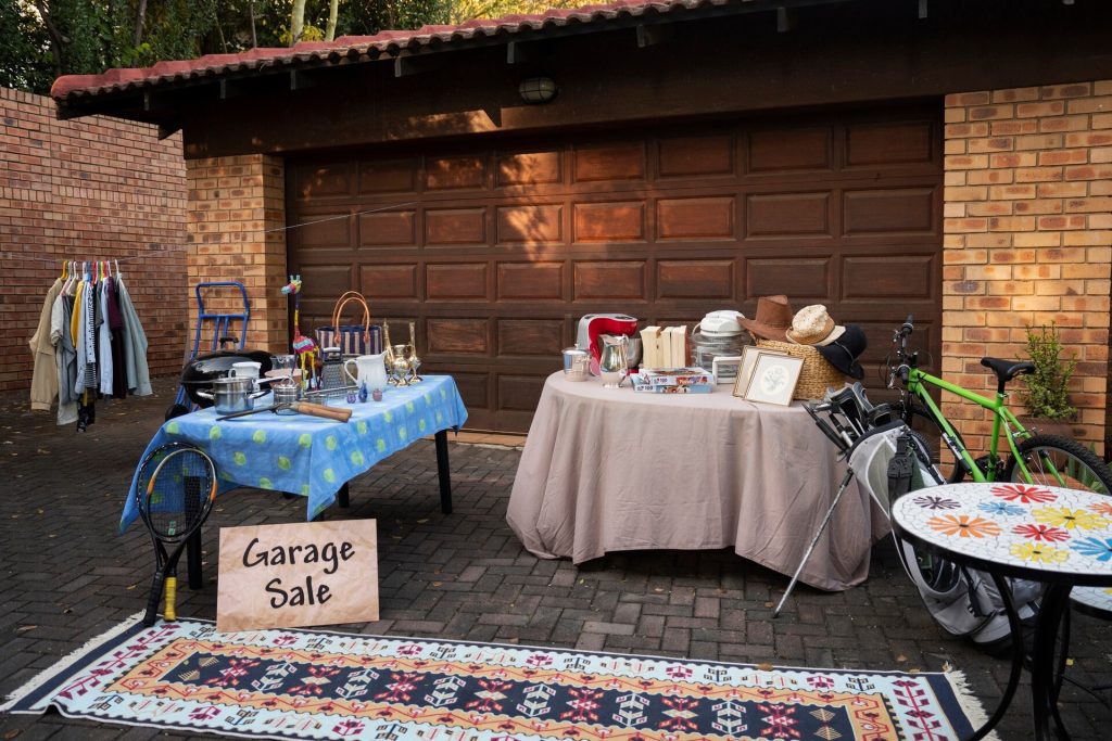 Begagnade saker till salu på en gårdsloppis framför ett garage